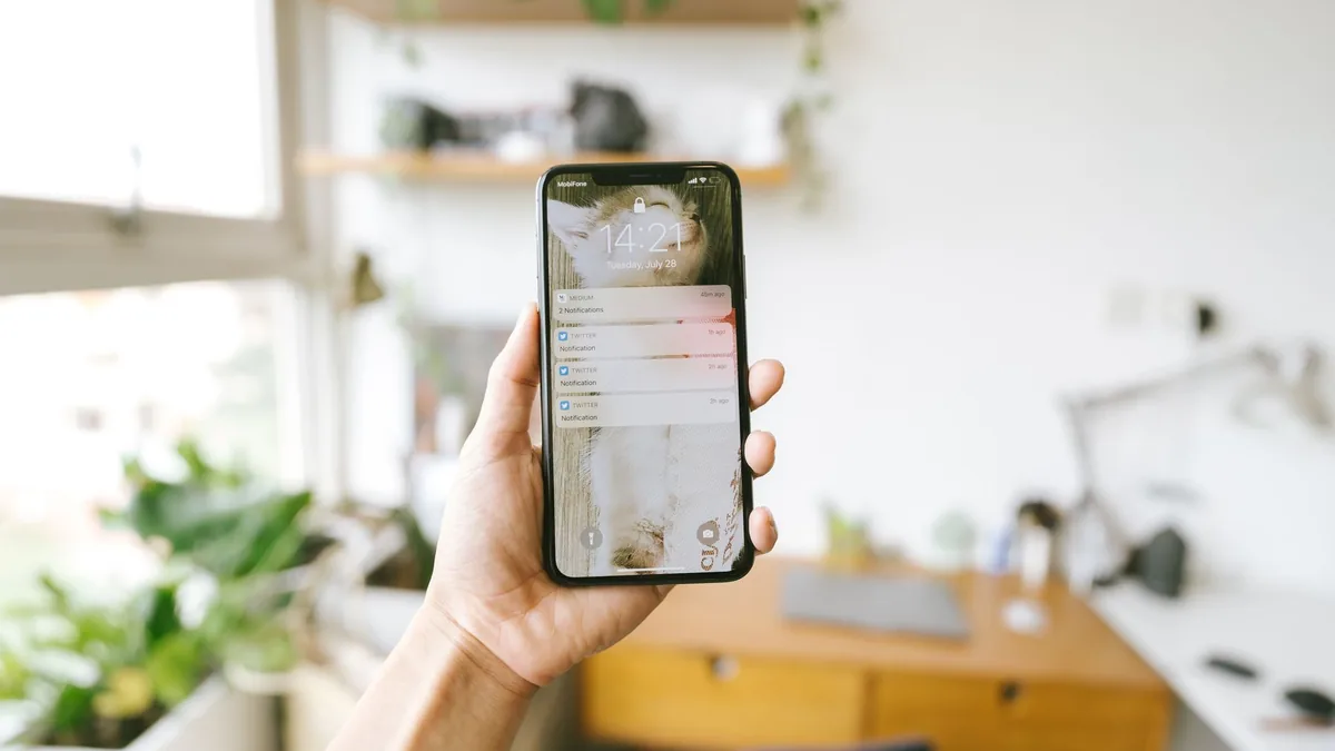 A hand holding a phone showing a text message notification