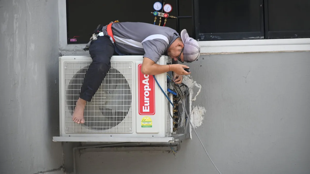 An HVAC technician servicing an air conditioning unit